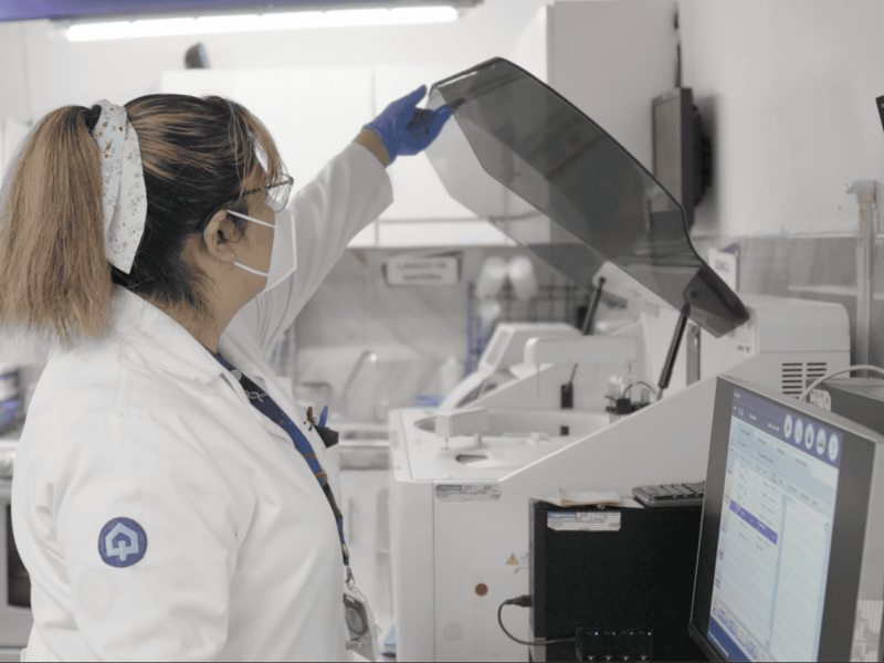 Técnica de laboratorio en Comunilab con equipo avanzado y personal especializado.